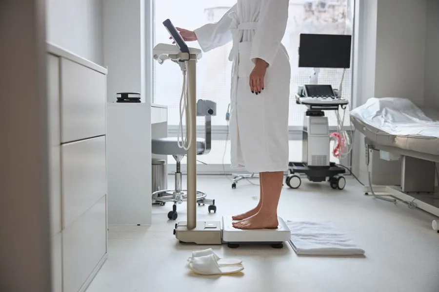 woman checking metabolic health on body weight scale